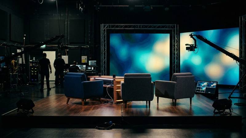 Trois fauteuils vides face à des écrans lumineux sur un plateau de talk-show en soirée, photo d'illustration sans lien direct avec les émissions citées