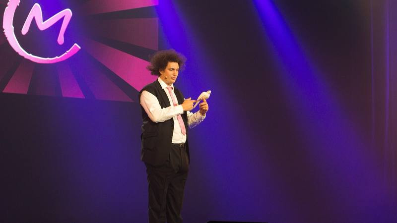 Éric Antoine, l'animateur de la soirée, sur la scène du Casino de Paris en juillet 2012, un spectacle de magie avec une colombe sur la main