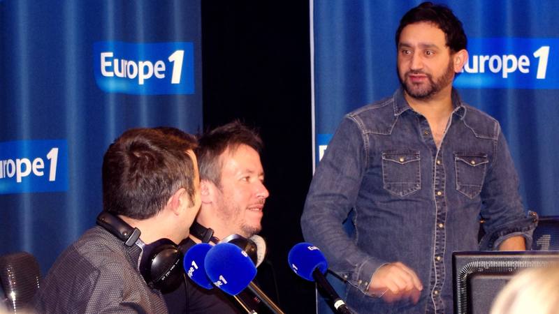 Cyril Hanouna lors d'un enregistrement dans un studio de radio, devant des micros