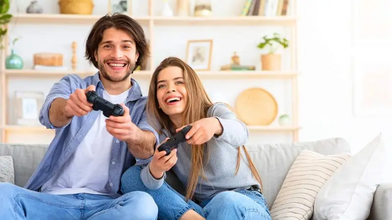 Deux joueurs manette en main sur un canapé, illustration de la stratégie jeux vidéo de TF1