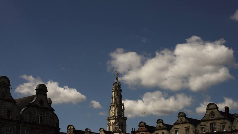 Le beffroi et les façades flamandes de la Grand-Place d'Arras sous un ciel bleu, ville de la première capture connue de Wanted