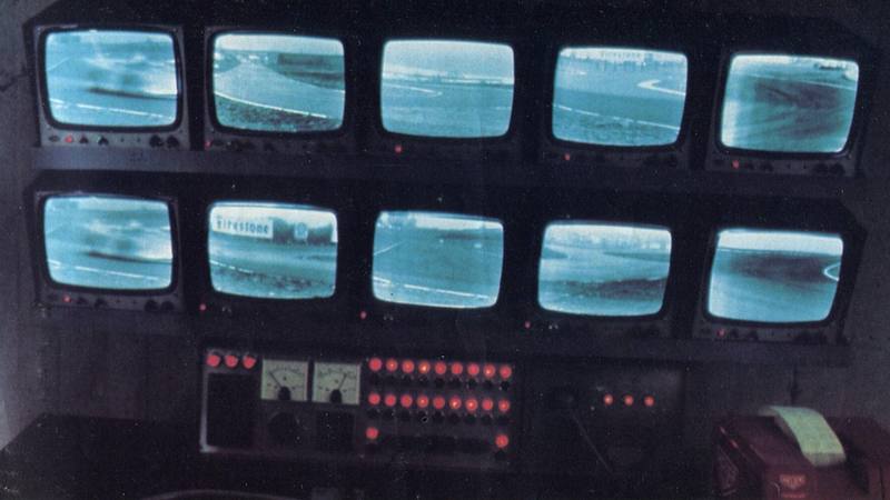 Mur de dix écrans de vidéosurveillance et pupitre de contrôle, photographie d'archive de 1972 d'une salle de contrôle du circuit de Fiorano, en Italie